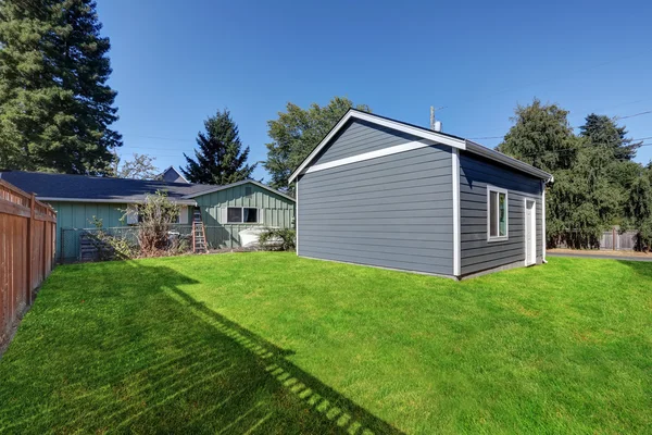 Grass filled back yard with Detached garage