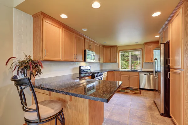 Maple kitchen cabinetry, granite counter top and tile floor