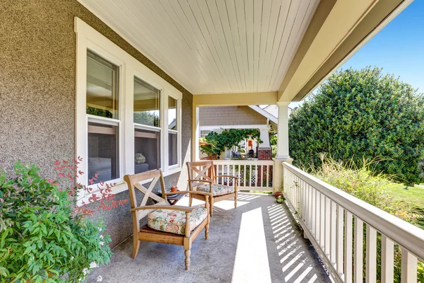 Front covered porch with outdoor furniture.