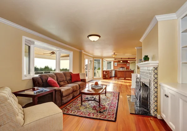 Craftsman-style family room with brown sofa and fireplace.