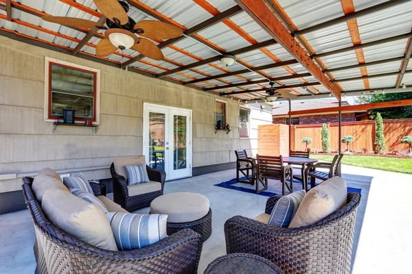 Covered back deck with concrete floor and outdoor furniture.