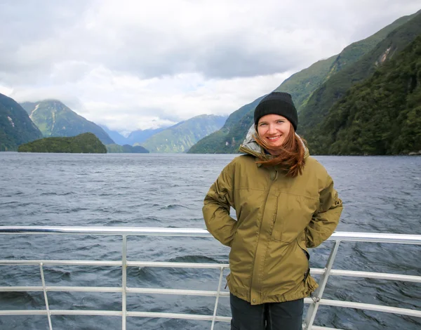 Young smiling woman  standing on the deck of touring boat. New Zealand