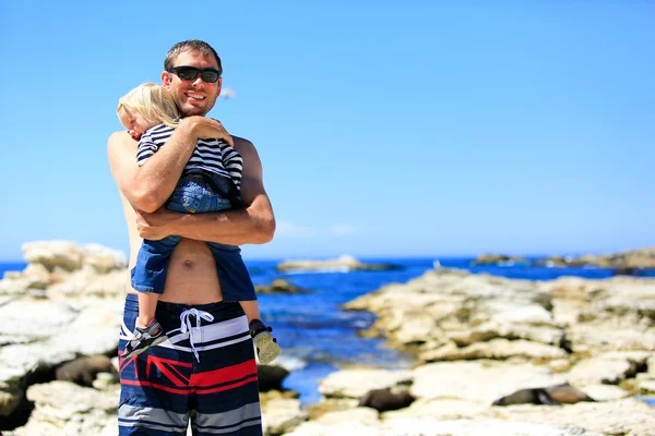 Young father with little daughter on Rocky coast at Kaikoura Peninsula