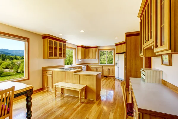 Light brown kitchen cabinets, white appliances and hardwood floor