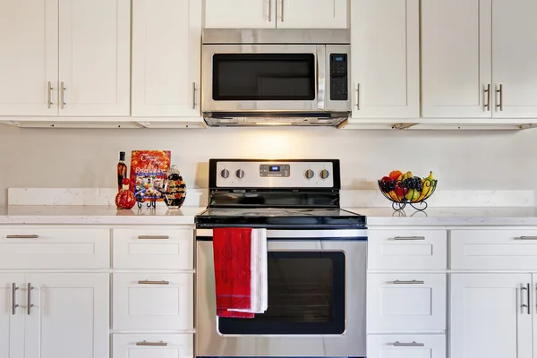 Bright kitchen room with steel appliances and granite tops