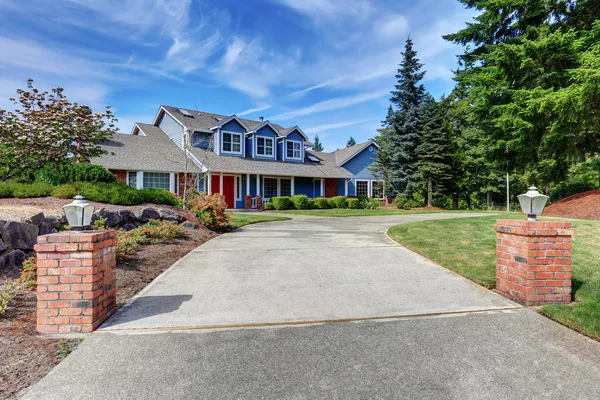 American house exterior with blue and white trim. Also red front door