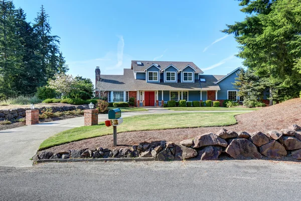 American house exterior with blue and white trim. Also red front door