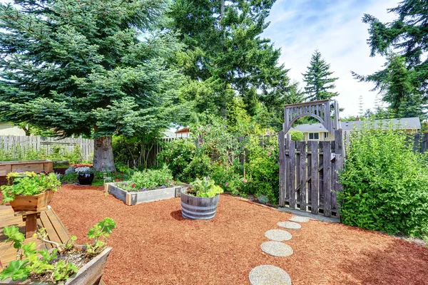 Fenced backyard area with well kept garden