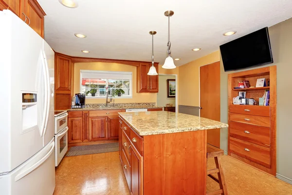Kitchen room interior with island, wooden cabinets and granite counter top.