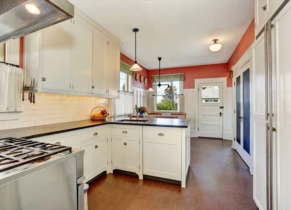 Classic kitchen room with white cabinets, granite counter top and hardwood floor.