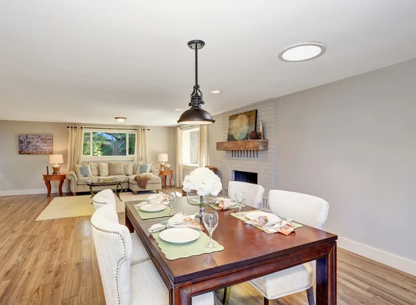 Open floor plan dining area with elegant table setting and white soft chairs.