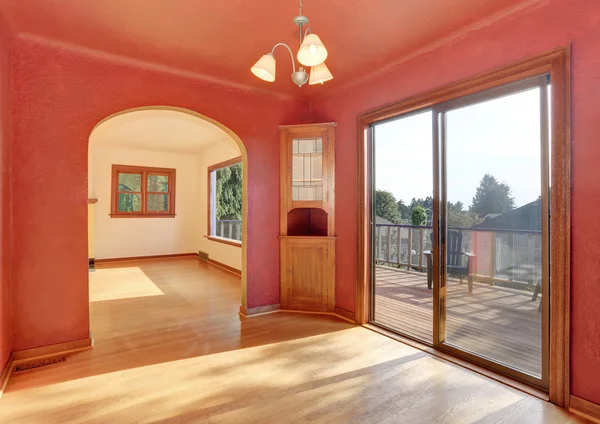 Hallway interior in red tones with hardwood floor. The room has exit to balcony.