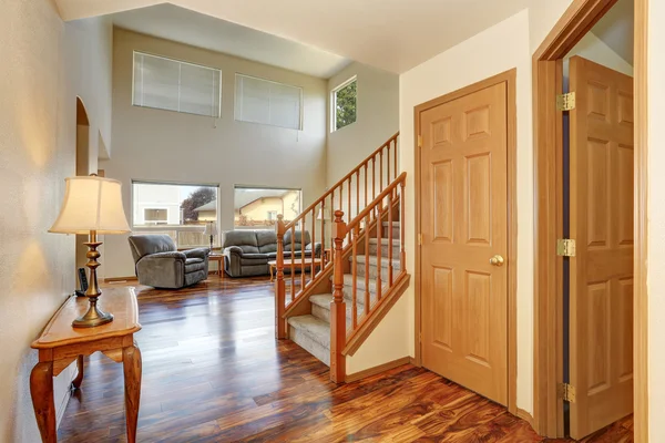 Classic hallway interior with hardwood floor. View of stairs to second floor