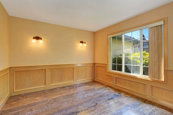 Empty room interior with tile floor and wooden trim walls