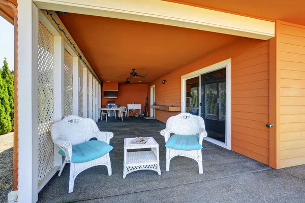 Cozy covered patio area of orange house
