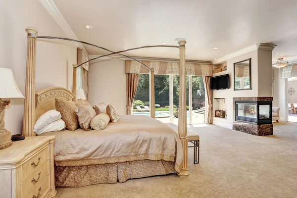 Large master creamy tones bedroom in luxury home.