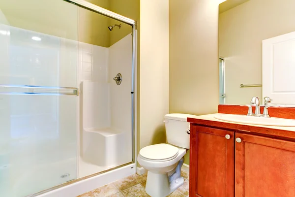 Simple bathroom interior with vanity cabinet and glass door show