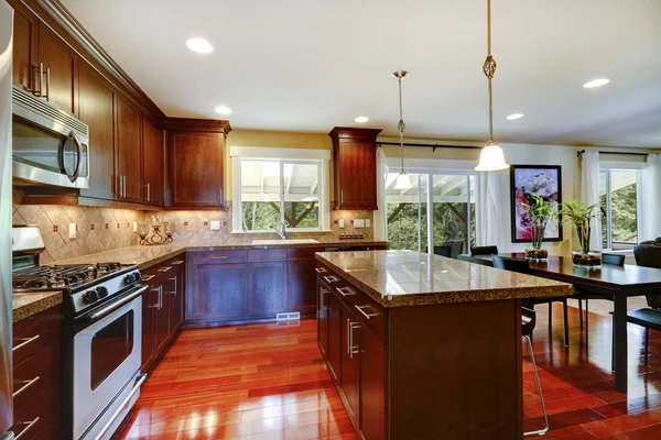 Shiny kitchen room with granite tops and steel appliances