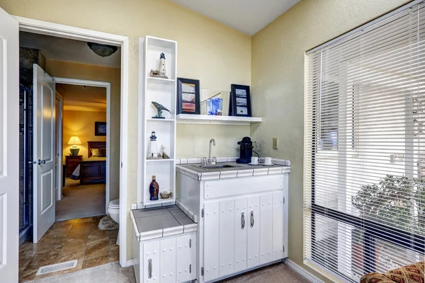 Sun room corner with cabinets and shelves