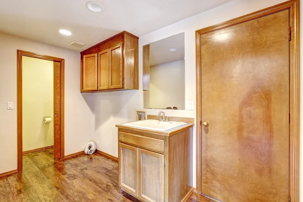 Empty bathroom with wooden cabinets