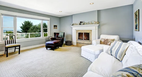 Light blue living room with white sofa and fireplace