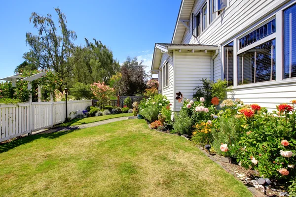 House with front yard landscape and white fence