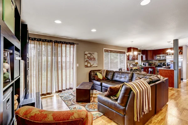 Family room with leather couch and kitchen area