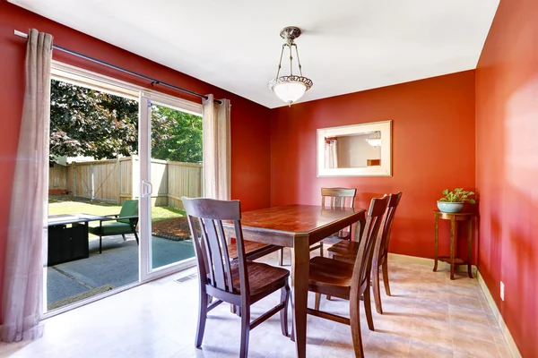 Dining area with bright red walls and walkout patio
