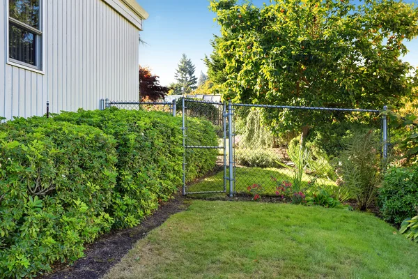 Backyard with trimmed bushes and gate