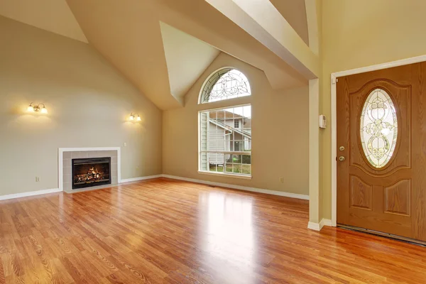 Empty living room with fireplace nd big arch window