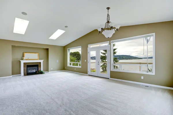 Empty spacious living room with walkout deck and fireplace.