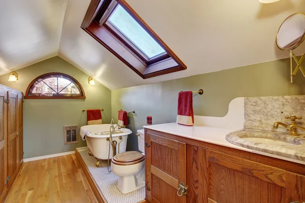 Vintage bathroom with hardwood floor and vaulted ceiling.