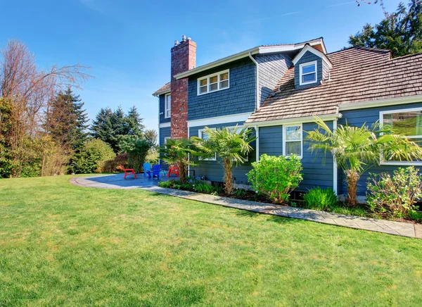 Perfect back yard with chairs, patio, and an abundance of greene