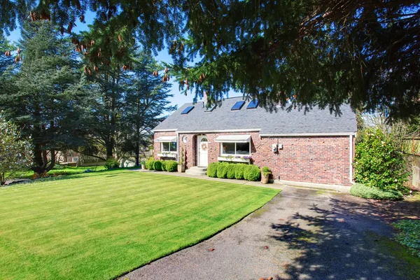 Traditional brick house with very well kept lawn.