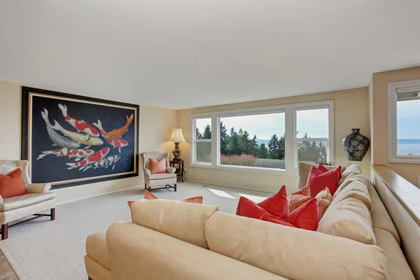 Excellent living room with large painting and windows.