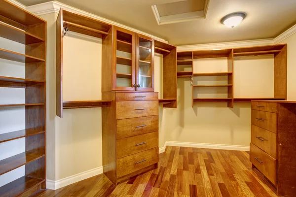 Large walk in closet with many shelves and drawers.