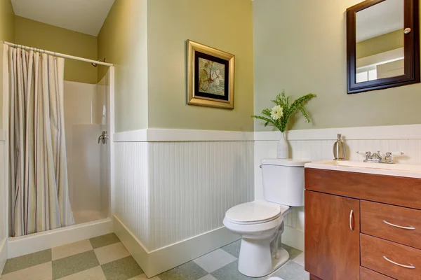 Bathroom with checkered tile floor, and green white walls.