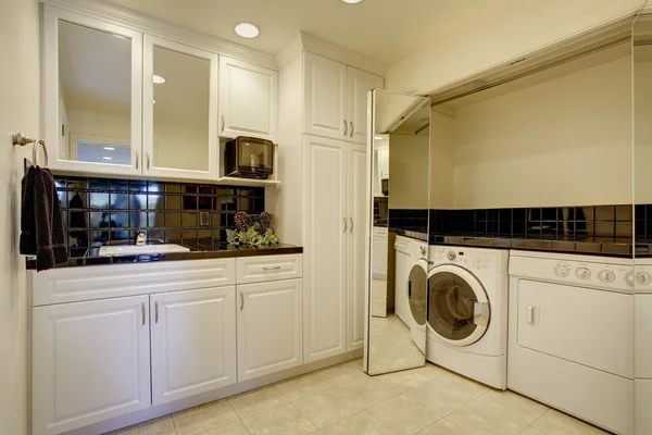 Laundry room with washer dryer, and miror folding doors.