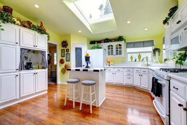 Perfect kitchen with white interior, yellow walls, and hardwood