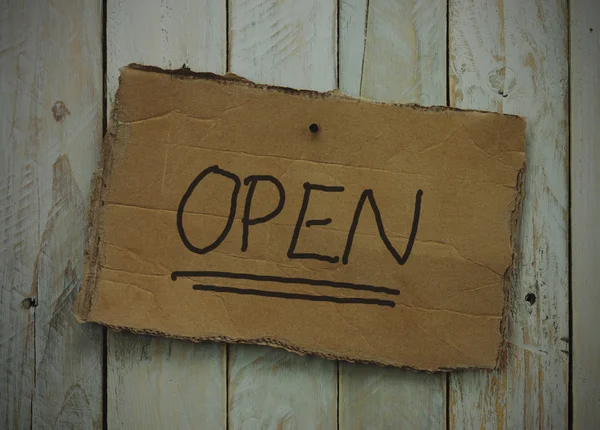 Cardboard sign on a wooden background