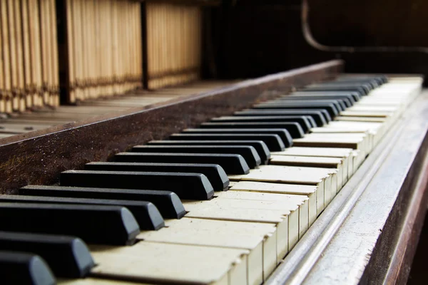 Old broken disused piano with damaged keys