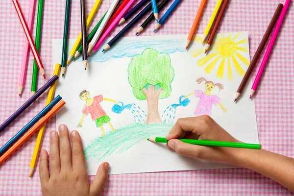 Child paints a picture of pencils about protecting nature.