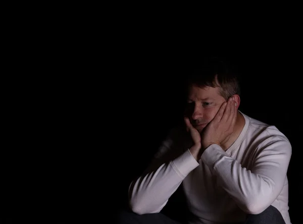 Mature man showing depression with dark background