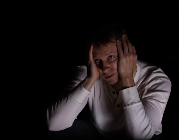 Lonely mature man showing depression with dark background