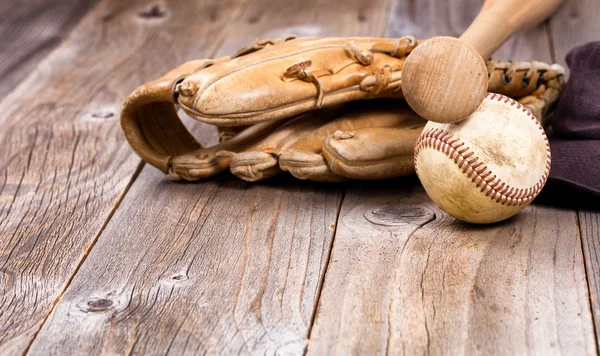 Used baseball equipment on rustic wooden boards
