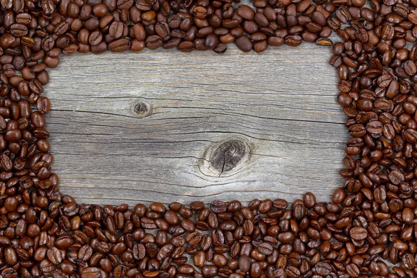 Border of freshly roasted coffee beans on aged wood