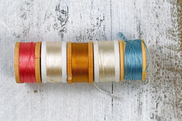 Many colors of thread within their spools