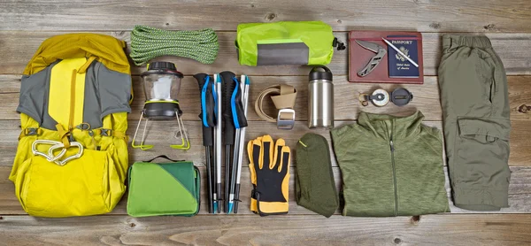 Hiking and camping gear organized on rustic wooden boards