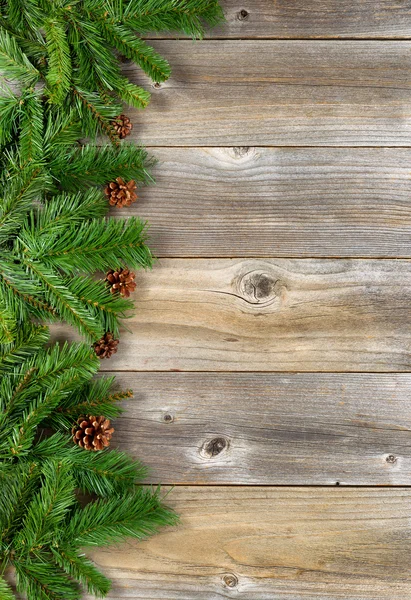 Christmas border with evergreen branches on rustic wooden boards