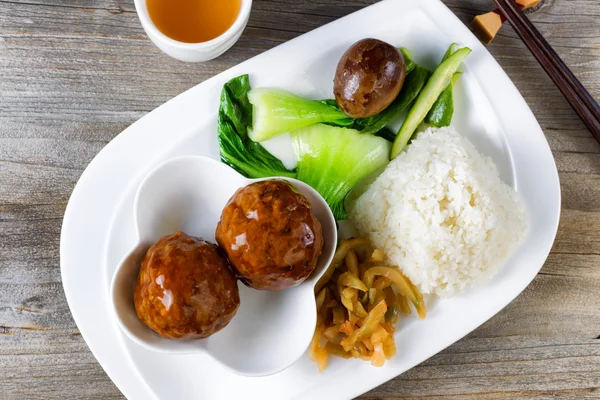 Saucy meatball dish in white plate ready to eat